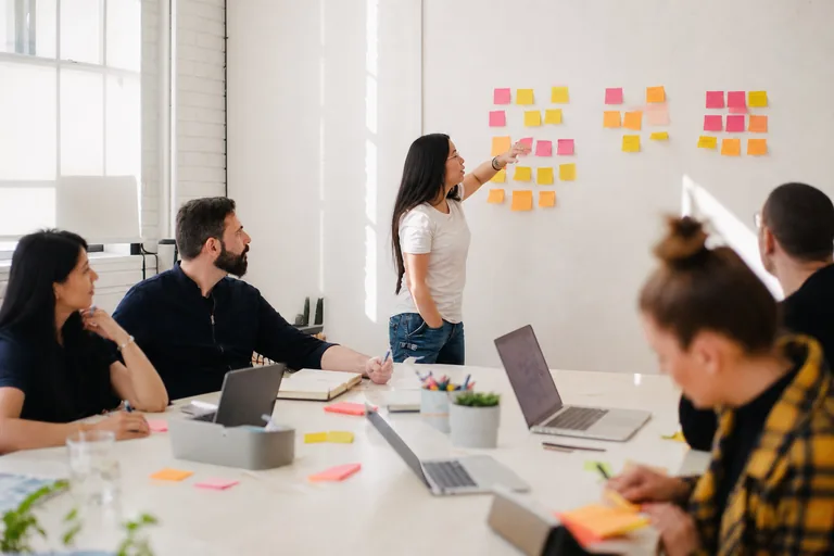 Candidates developing ideas with a facilitator during a Post-it note workshop